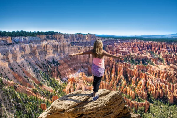 Happy woman with raised arms on mountain top in Bryce Canyon. stock photo