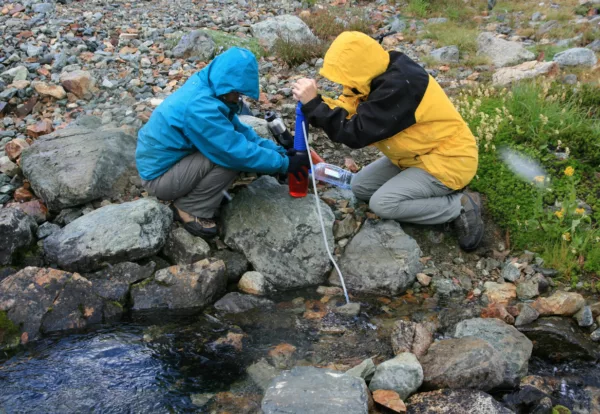 Women Filtering Water from Creek