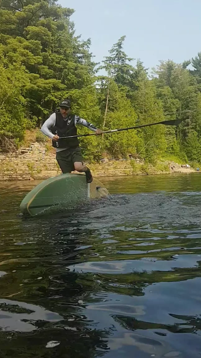Yann Fortin does a kickflip with his SUP on a river in Quebec